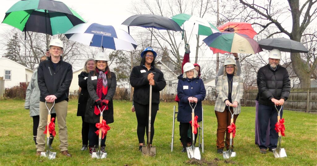 Brittni (center, left) and representatives from Habitat Capital Region, Ingham County Land Bank, and Ingham County Treasurer's Office break ground at the site of her future Habitat house!