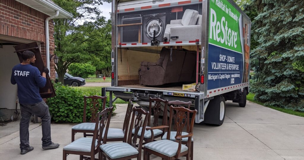 A ReStore Associate/Driver carries a donation to the ReStore truck.